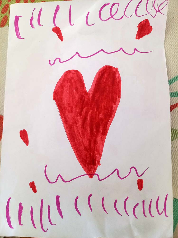 Child’s drawing featuring a large red heart and decorative lines