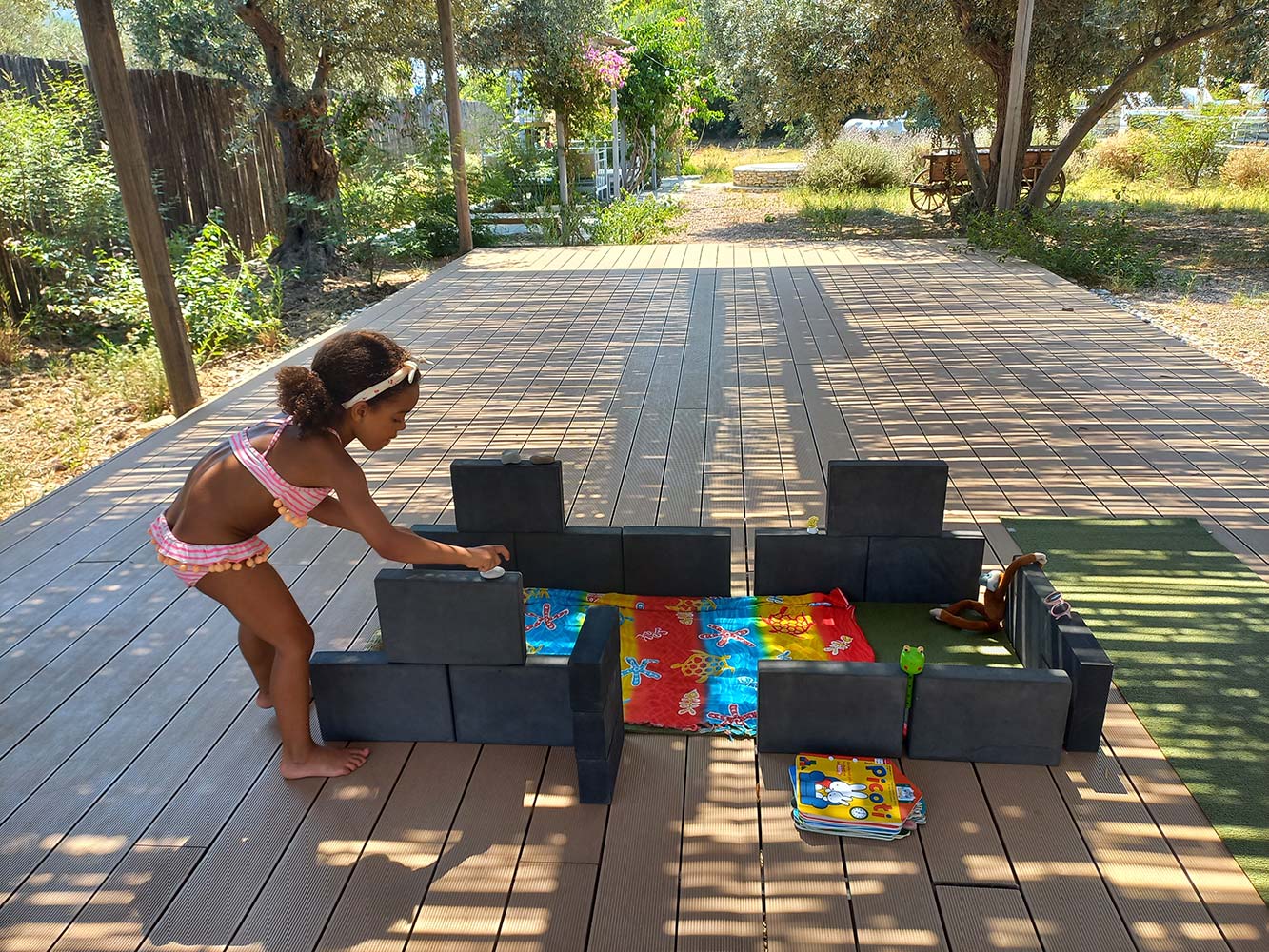 Child building with large foam blocks in an outdoor play space in Sifnos